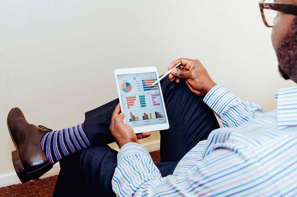 Young man analysing data on his tablet