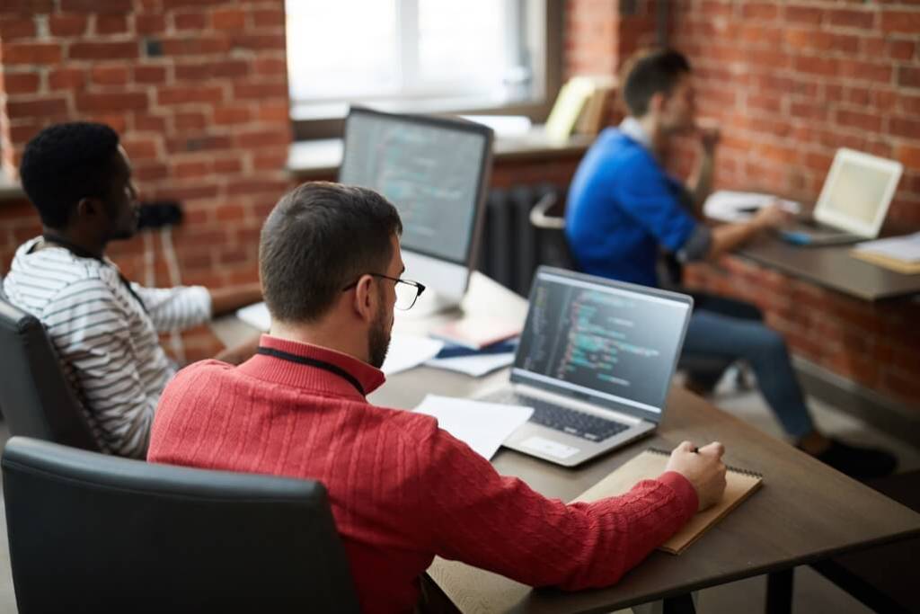 A team of web developers taking notes