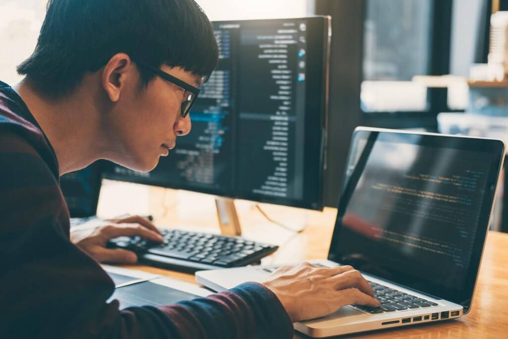 A web development professional using his laptop