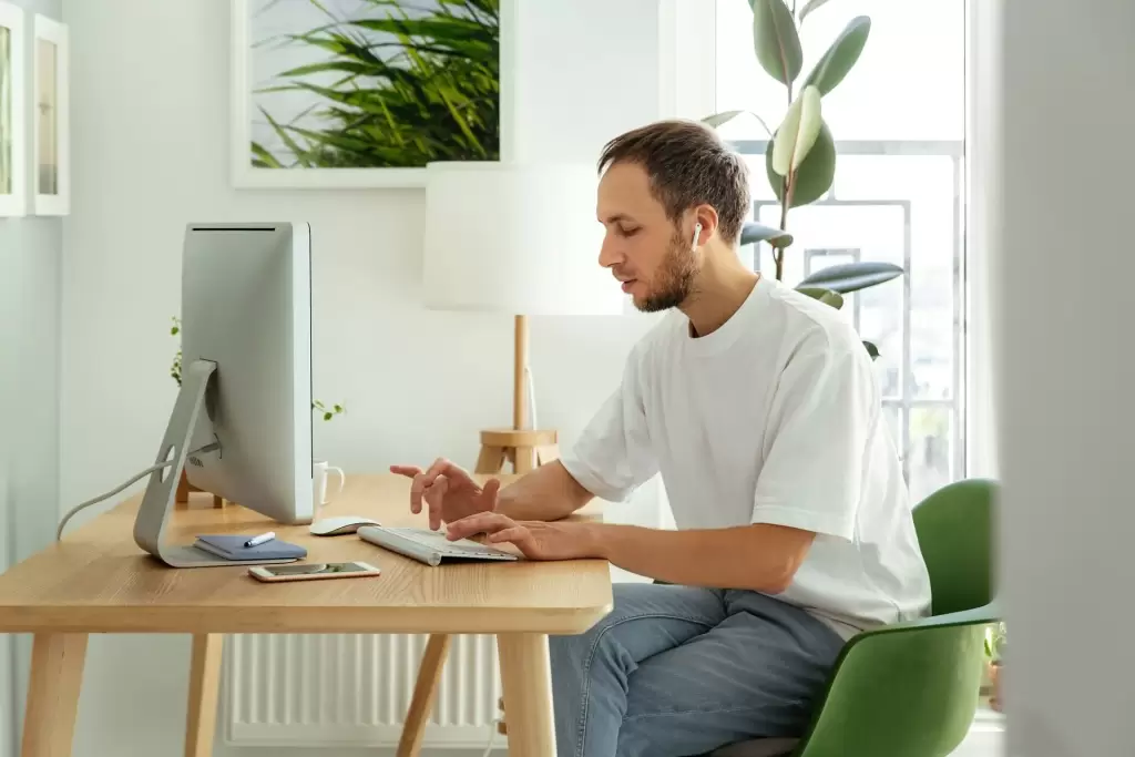 a person with white t shirt working on his pc